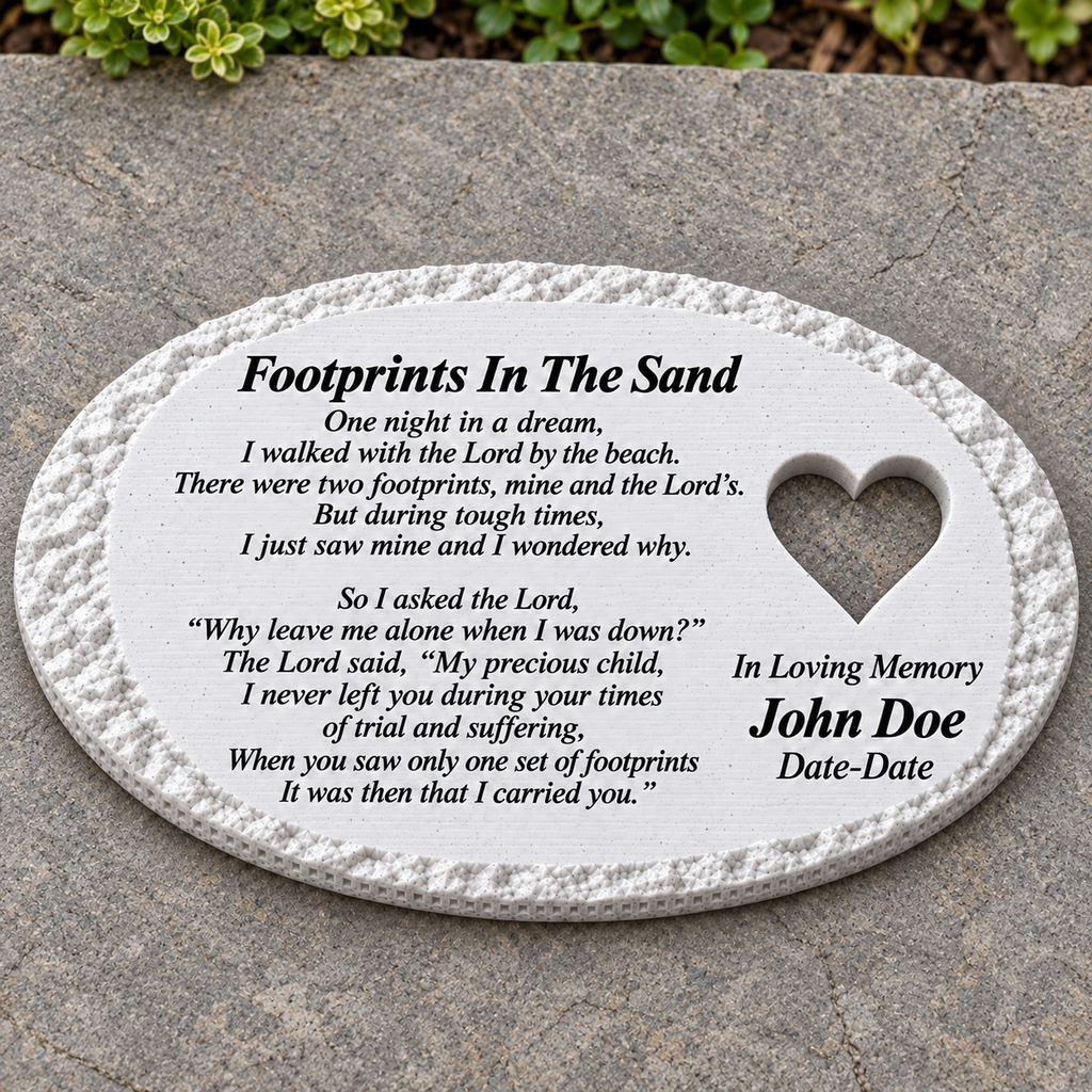 White rough oval memorial lying flat on a patio, with heart and Footprints In The Sand poem