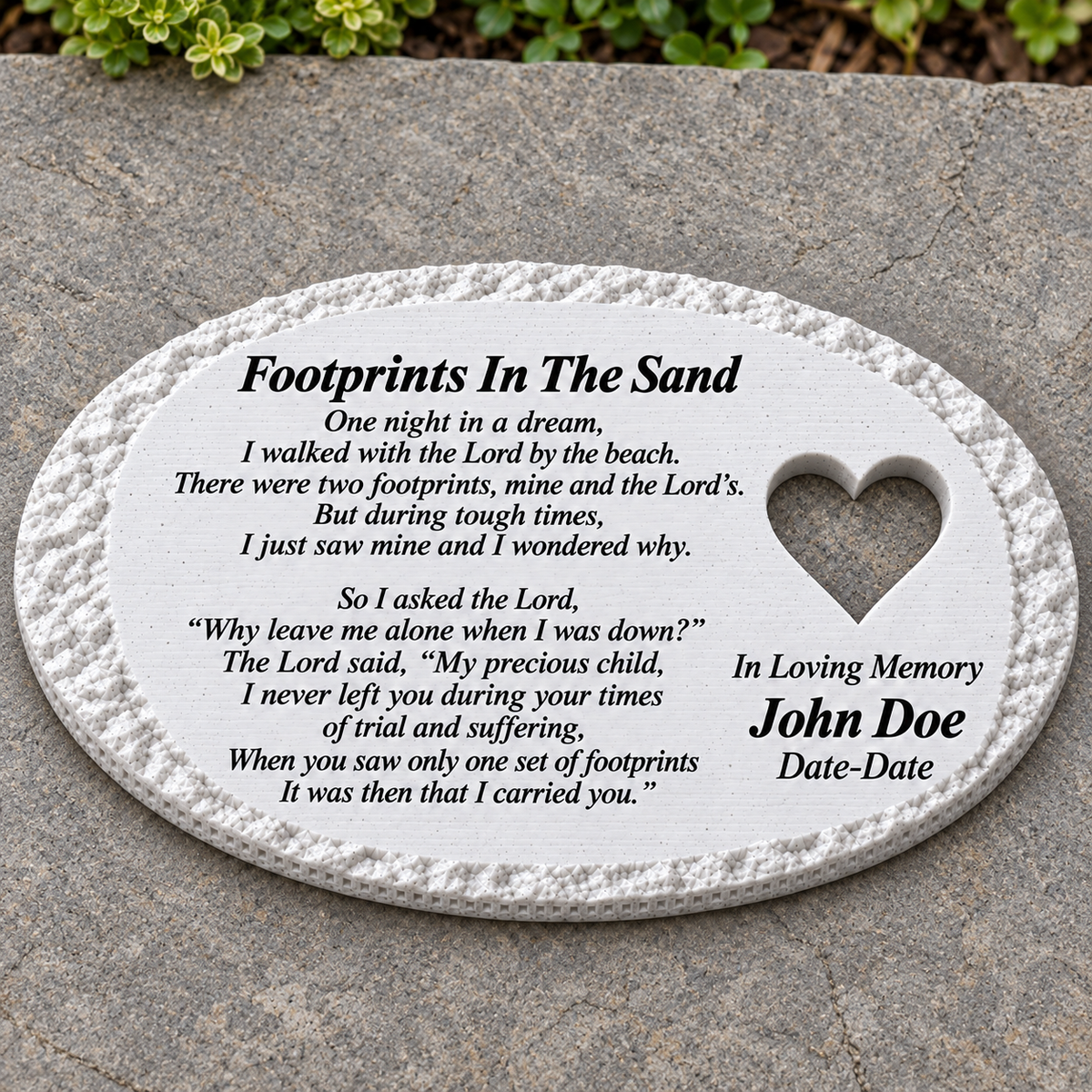 White rough oval memorial lying flat on a patio, with heart and Footprints In The Sand poem