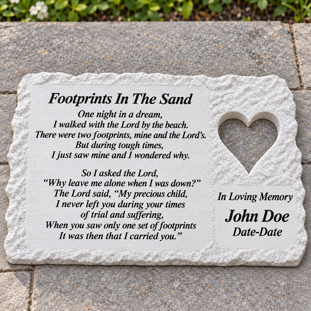 White rough rectangular memorial lying flat on a patio, with heart and Footprints In The Sand poem